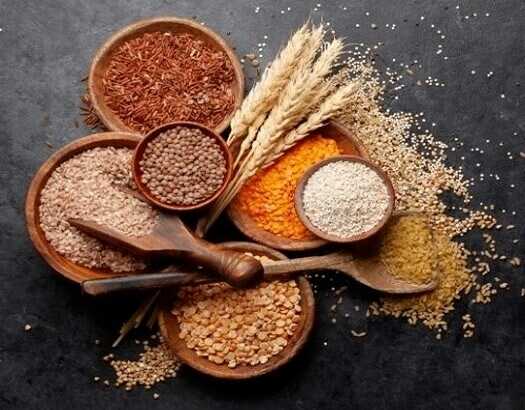 Zrnasti-plodovi-pirivač-lan-sočivo-susam-pšenica-u-drvenim-činijama-na-crnoj-podlozi.