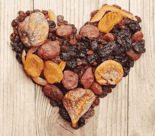Sušeno-i-kandirano-voće-u-obliku-srca-na-drvenoj-podlozi.